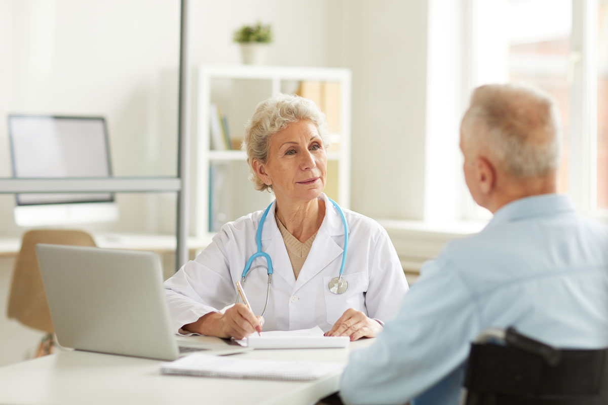 medicare-part-b-deductible Doctor talking with an older male patient during an outpatient office visit